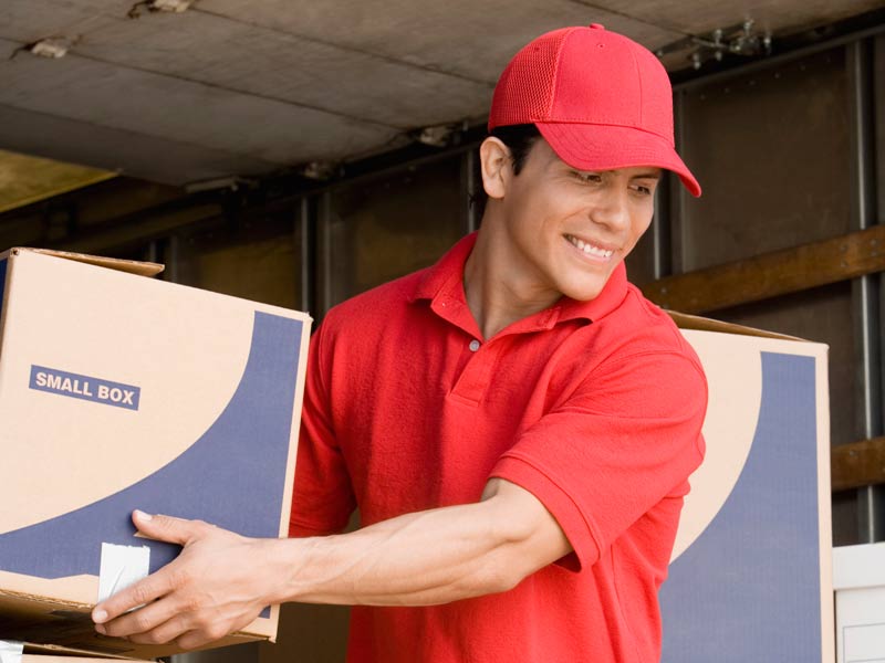 A shipping specialist unloading a box froma truck