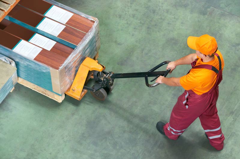 A freight specialist moving cargo on a pallet jack