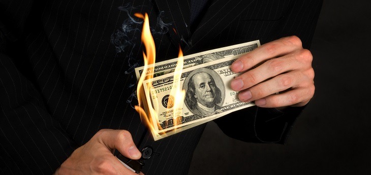 Businessman burning money in his hands