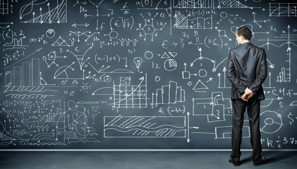 Businessman standing in front of a blackboard 