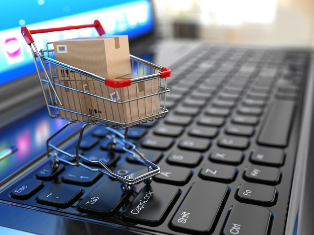 Shopping cart with cardboard boxes on laptop.