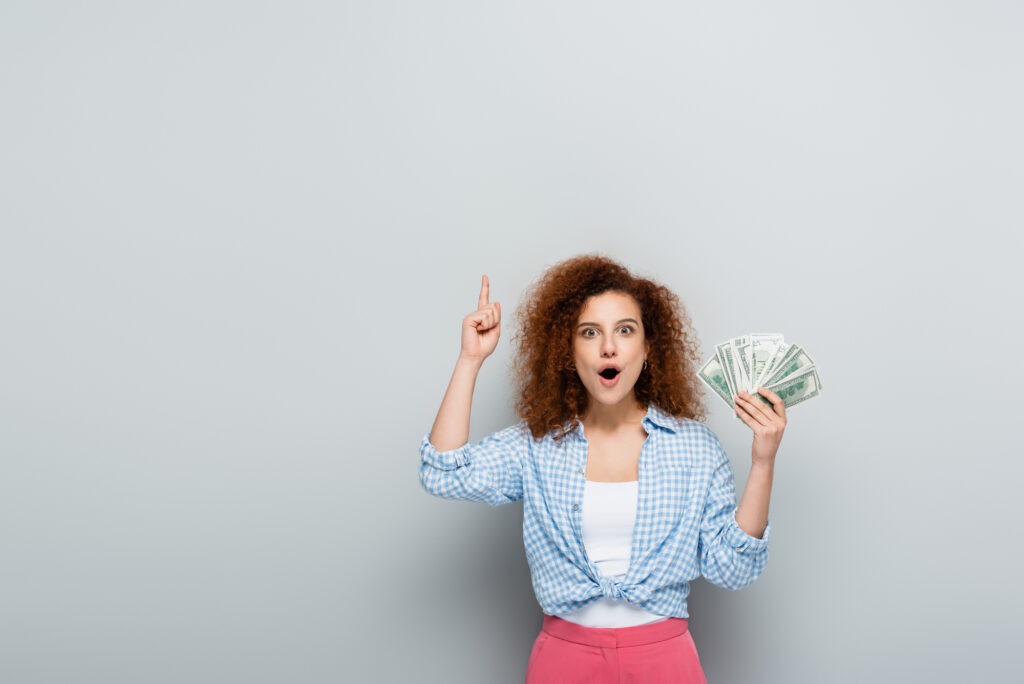 Woman holding money, point up with her finger