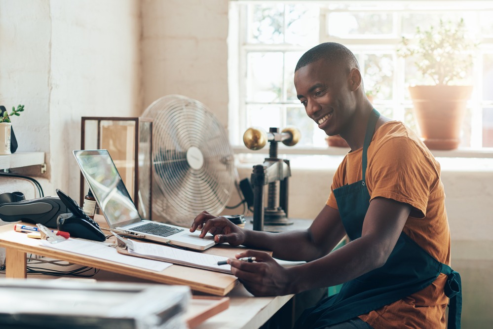 Man in a home office working at a desk with a laptop