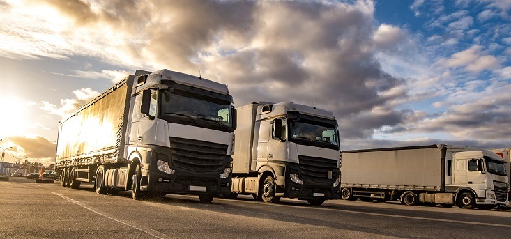 Trucks in a row with containers in the parking lot. Logistic and Transport concept