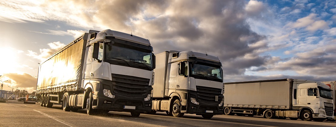 Trucks in a row with containers in the parking lot. Logistic and Transport concept