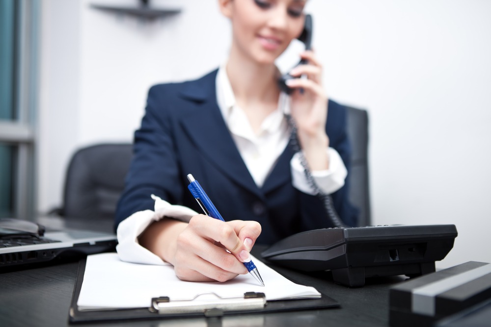 Business woman on the phone while taking notes