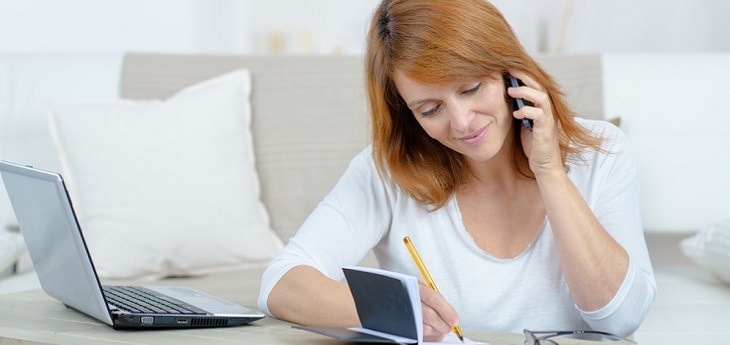 A woman on the phone scheduling an appointment