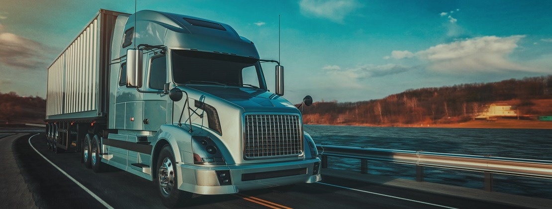 A freight truck moving by a river