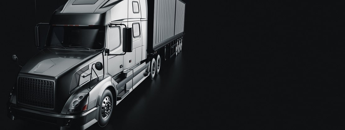 A black and white image of a dimly lit truck in a black background