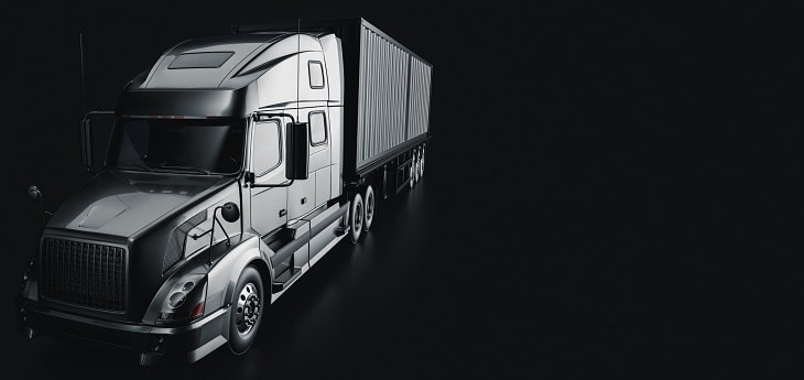 A black and white image of a dimly lit truck in a black background