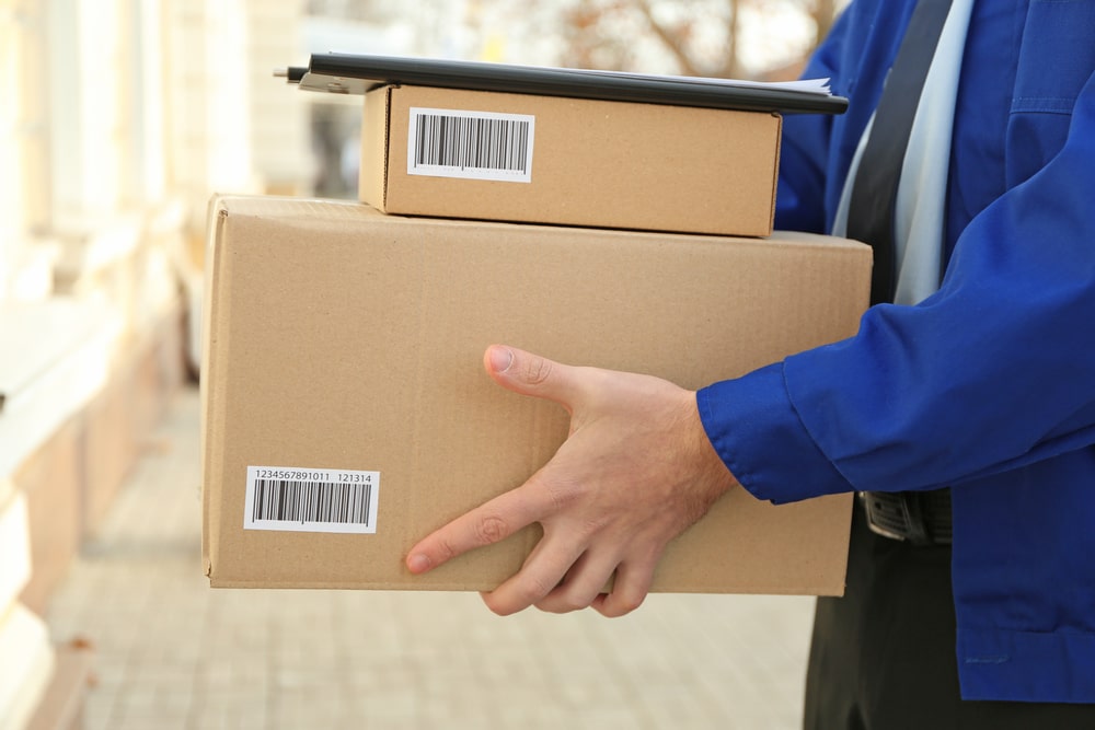 A man holding two parcel sized boxes