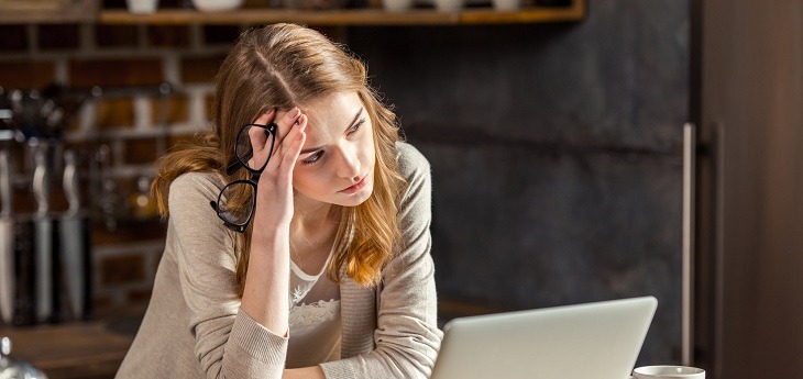 business woman looking at screen with a headache