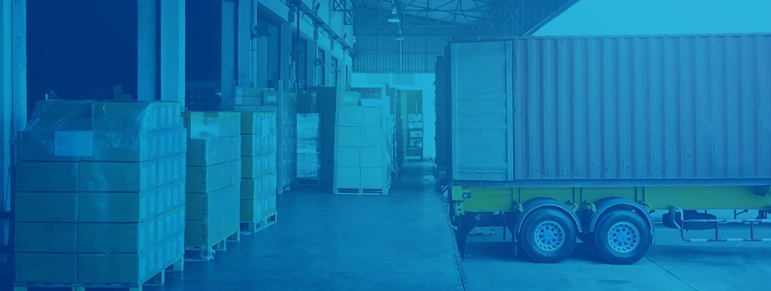 A freight truck parked by a loading dock awaiting loading or unloading