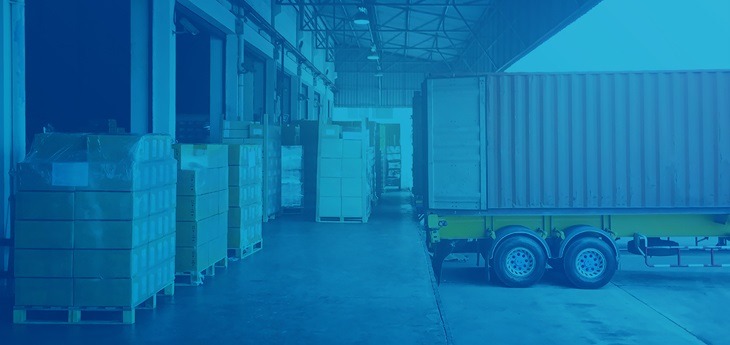 A freight truck parked by a loading dock awaiting loading or unloading