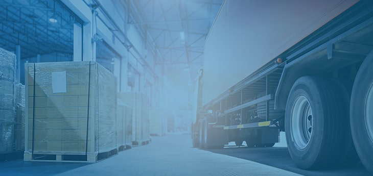 A freight truck moving through a warehouse next to a packaged pallet