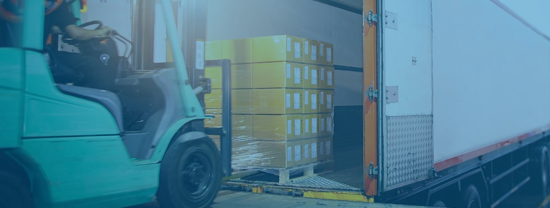 A forklift loading a pallet onto a truck