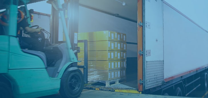 A forklift loading a pallet onto a truck