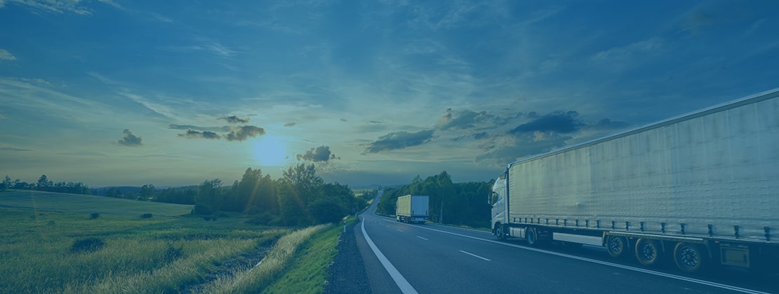 Freight trucks driving off into the sunset