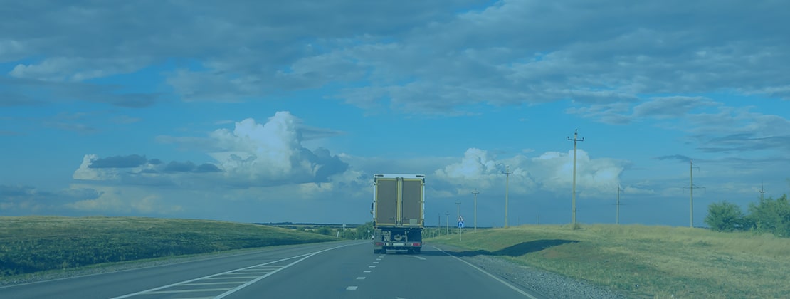 A freight truck driving off into the distance