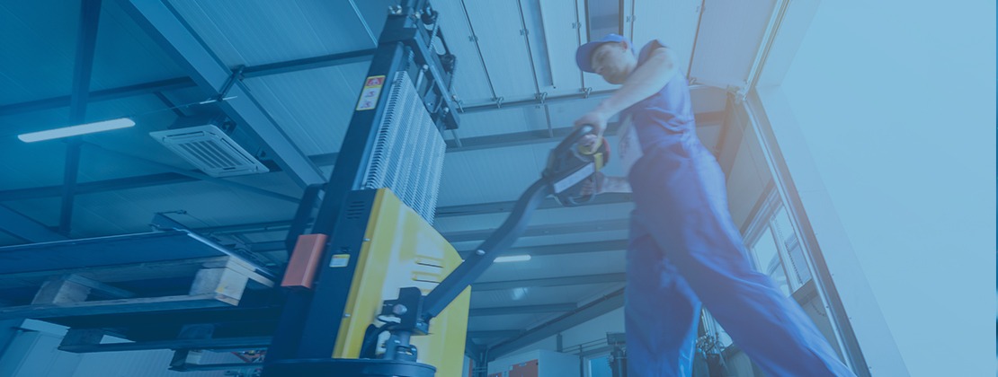 A dock worker operating a pallet jack to move heavy freight