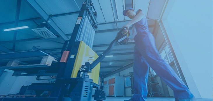 A dock worker operating a pallet jack to move heavy freight