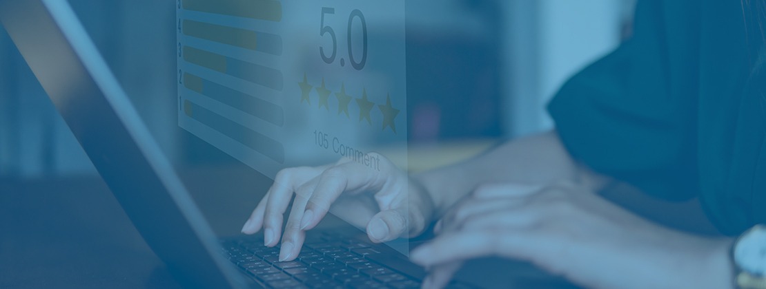 Person typing a laptop with a 5 star review in the background