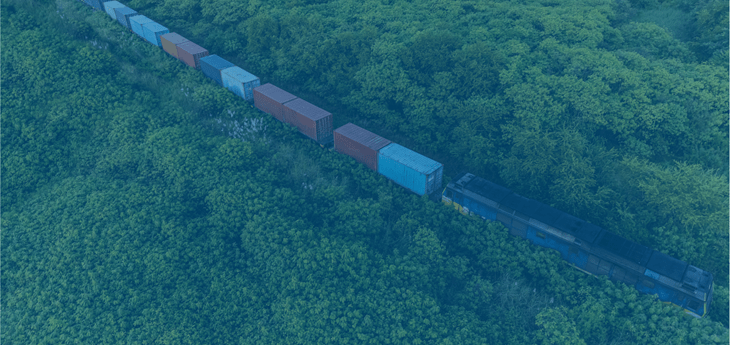 Freight train moving containers through a forrested area.