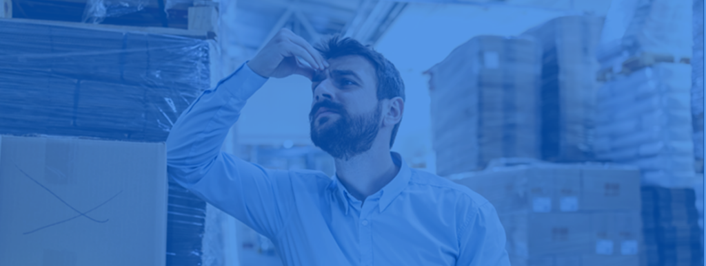 Man in warehouse holding his forehead