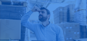 Man in warehouse holding his forehead