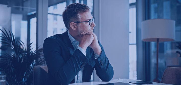 Businessman sitting at a desk, deep in thought