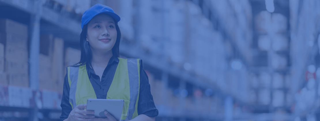 Female warehouse worker holding a clipnote in a warehouse.