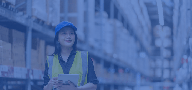 Female warehouse worker holding a clipnote in a warehouse.
