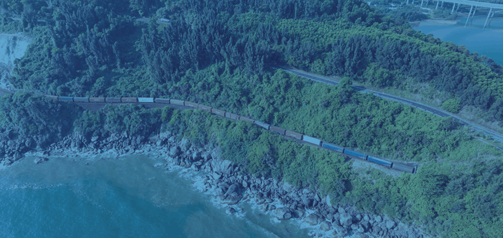 A freight train moving through a picturesque landscape.